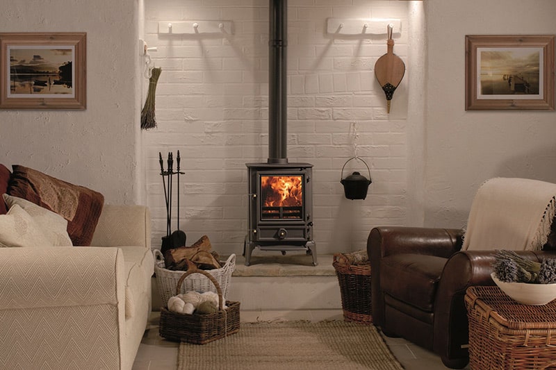 Burggeman - sfeerfoto Strakke woonkamer met grijzige tinten en een gietijzeren kachel van Fireplace Haarden